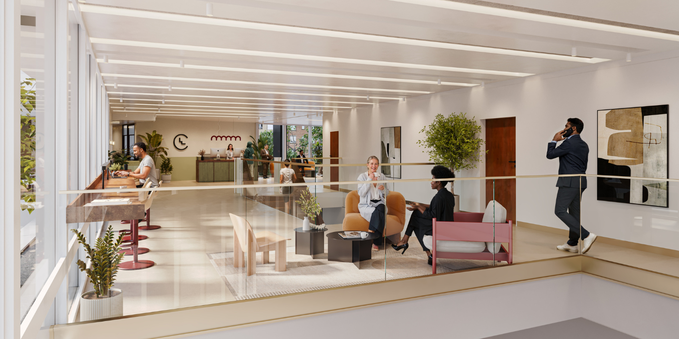 Un espace de travail moderne avec des employés travaillant à des bureaux ou assis sur des canapés ; une personne est au téléphone. De grandes fenêtres apportent de la lumière naturelle, et des plantes et des œuvres d'art décorent l'espace.